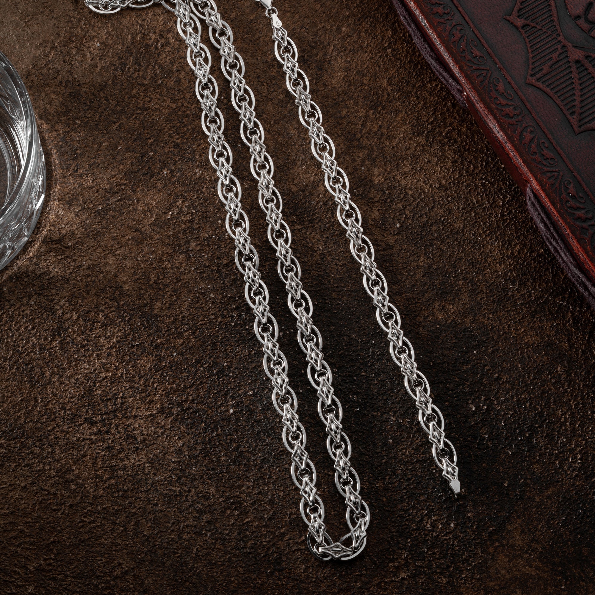 Sterling Silber MAGNUS Set von Ketten Boss, feine Ketten und Anhänger, elegante Schmuckstücke auf weißem Hintergrund
