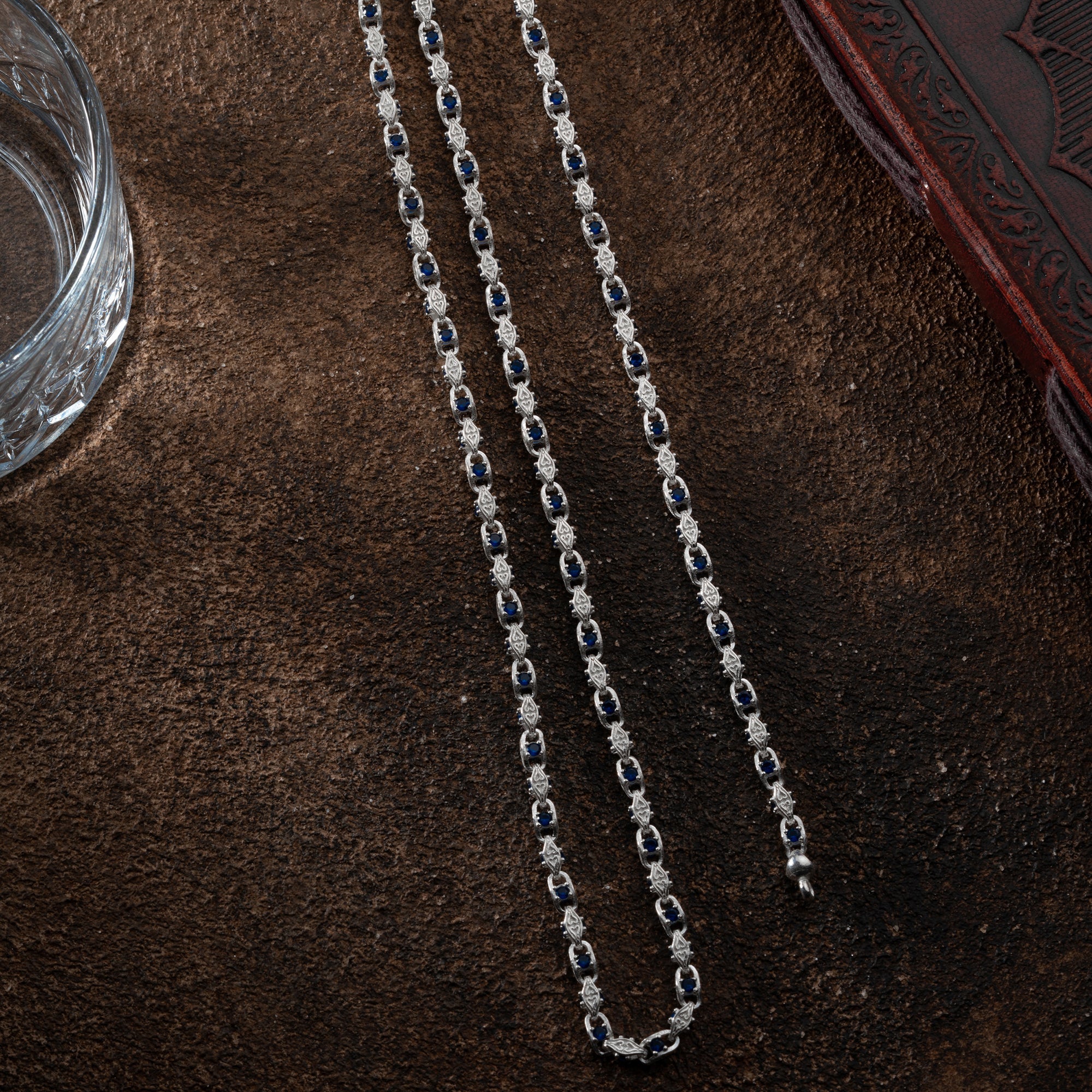 Anker Blue Diamond Set aus 925er Silber von Ketten Boss, mit blauen Diamanten und eleganten Schmuckstücken auf einem weißen Hintergrund.