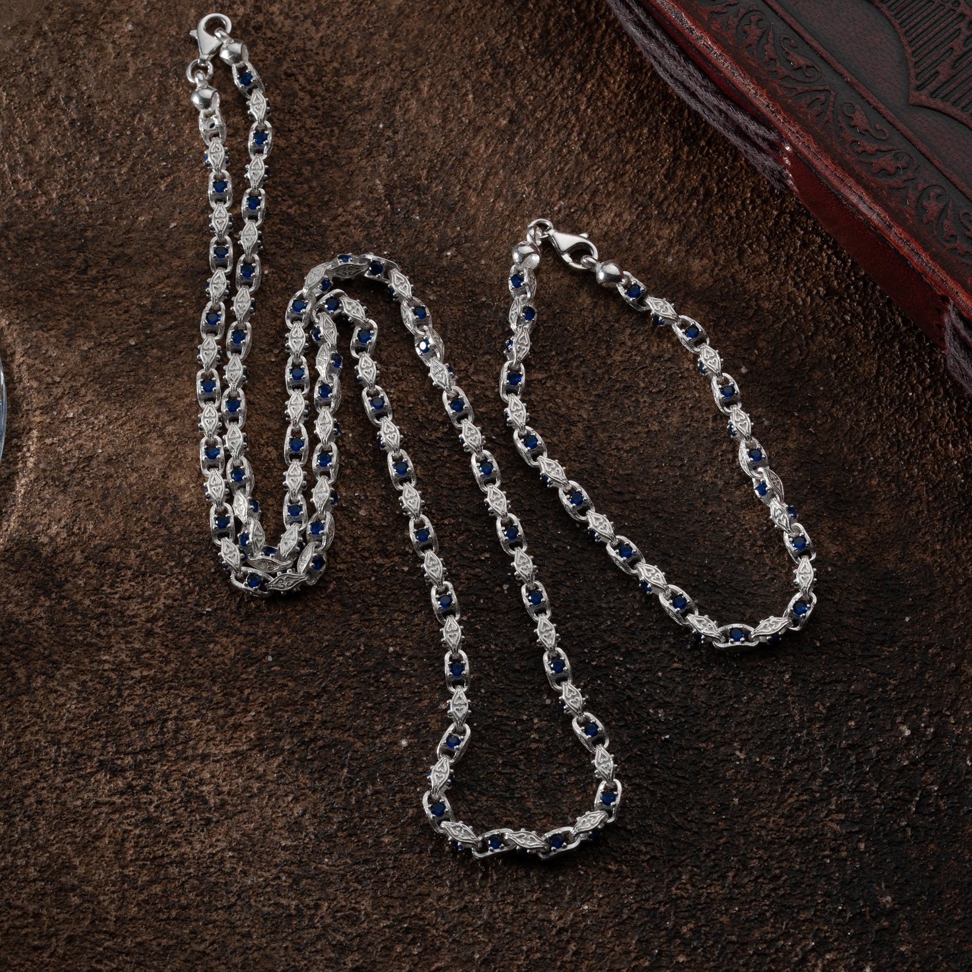 Anker Blue Diamond Set aus 925 Silber mit blauen Diamanten, elegant Ketten Boss Schmuck auf einem weißen Hintergrund