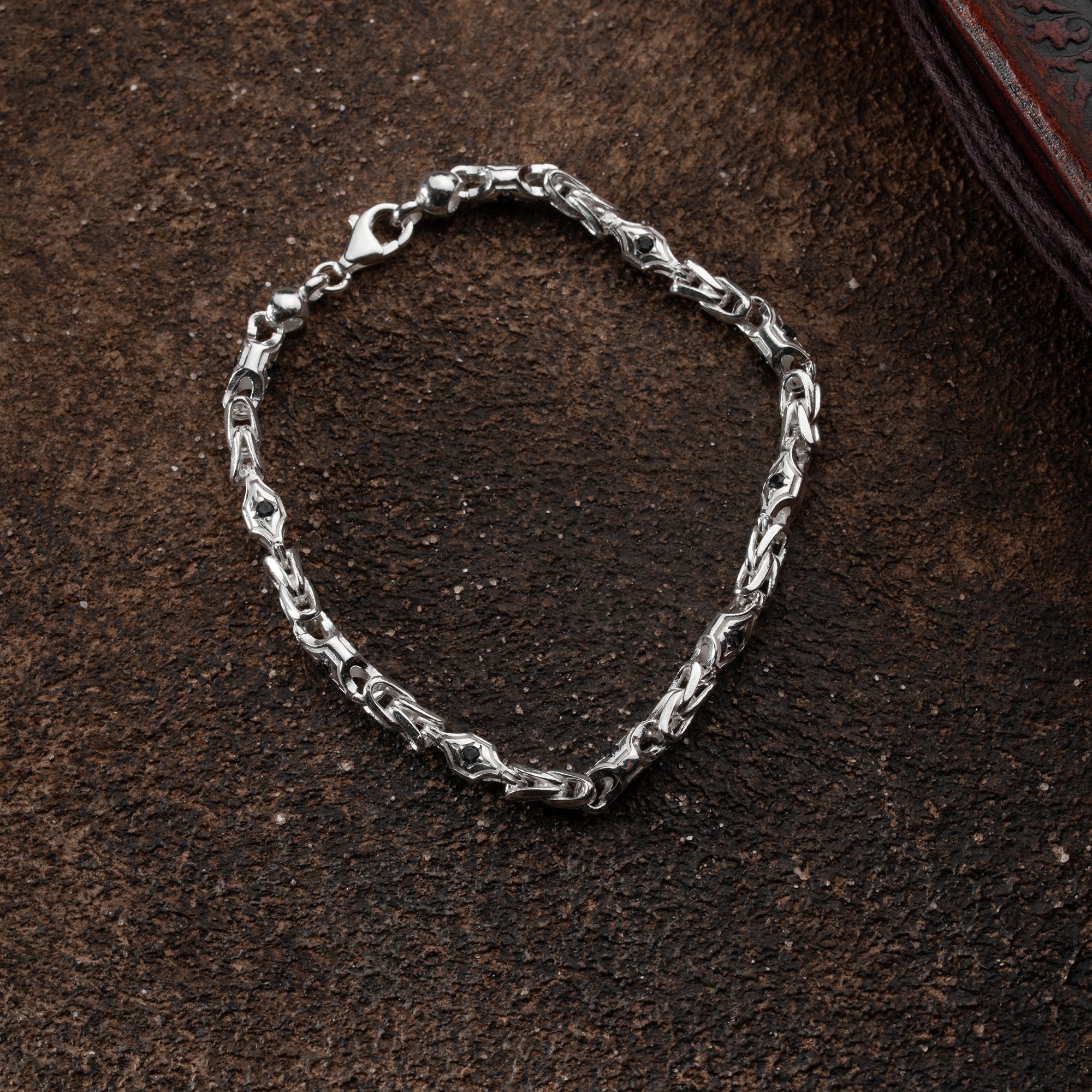MYX Armband aus 925 Silber mit 4 mm Breite, präsentiert von Ketten Boss, liegt auf einem weißen Hintergrund.
