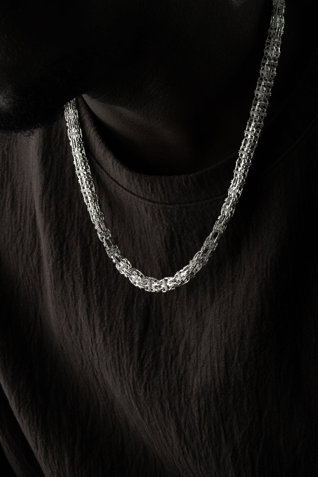 Silberkette aus 925 Silber von Ketten Boss, feine KÄFIGKETTE mit robustem Design, liegend auf weißem Hintergrund