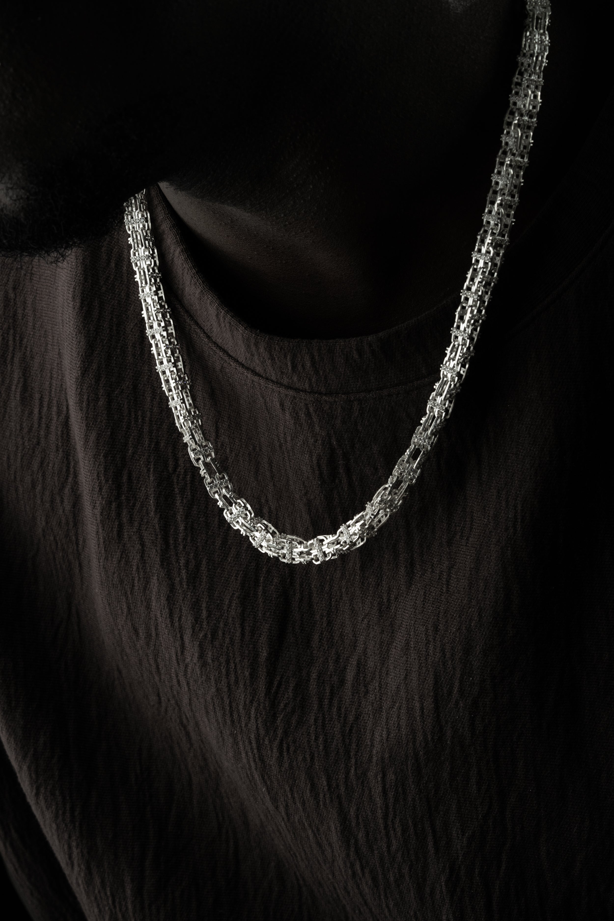 Silberkette aus 925 Silber von Ketten Boss, feine KÄFIGKETTE mit robustem Design, liegend auf weißem Hintergrund