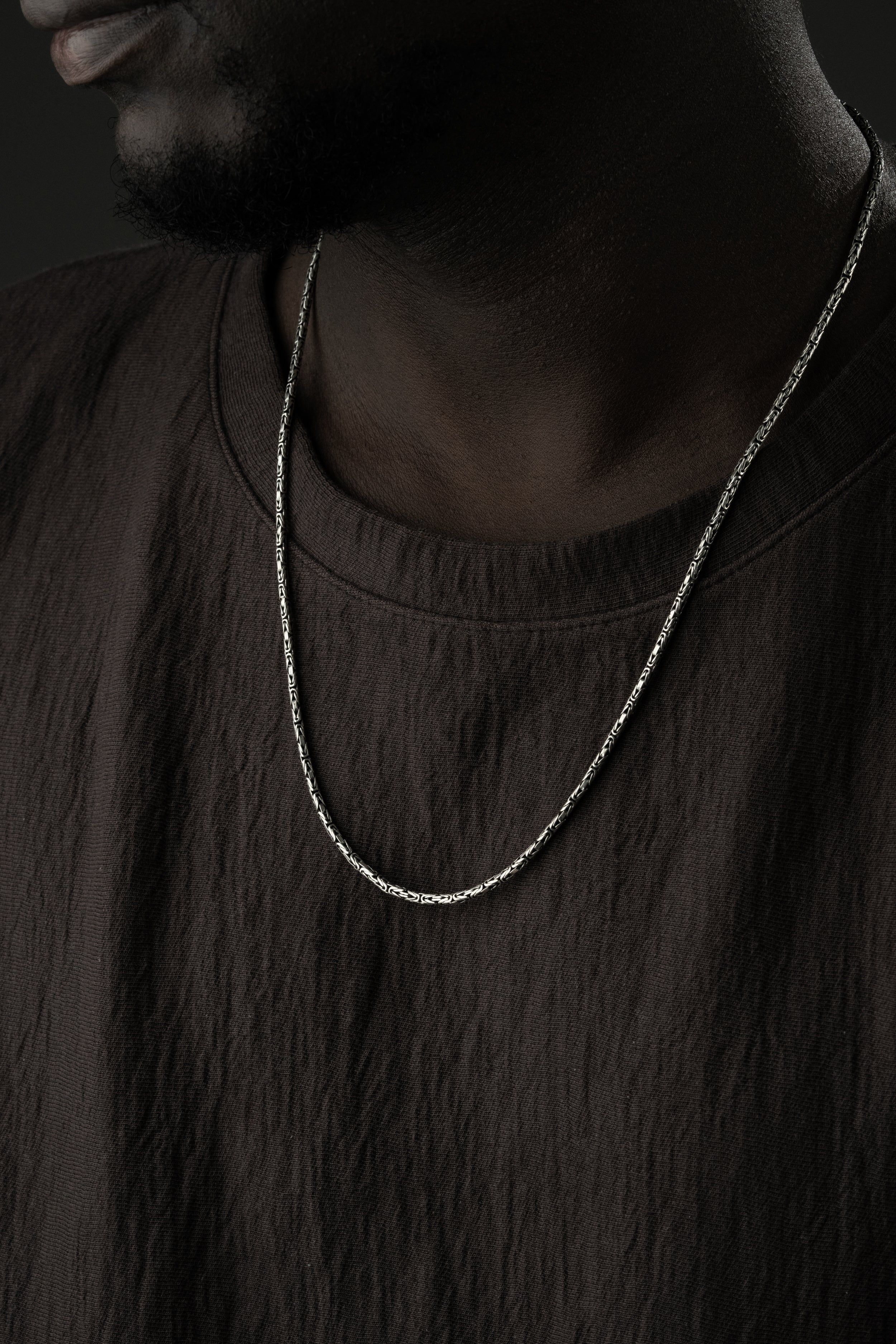 Oval Königs-Kette aus 925 Silber, 2mm Halskette mit glatter Oberfläche, liegend auf weißem Hintergrund